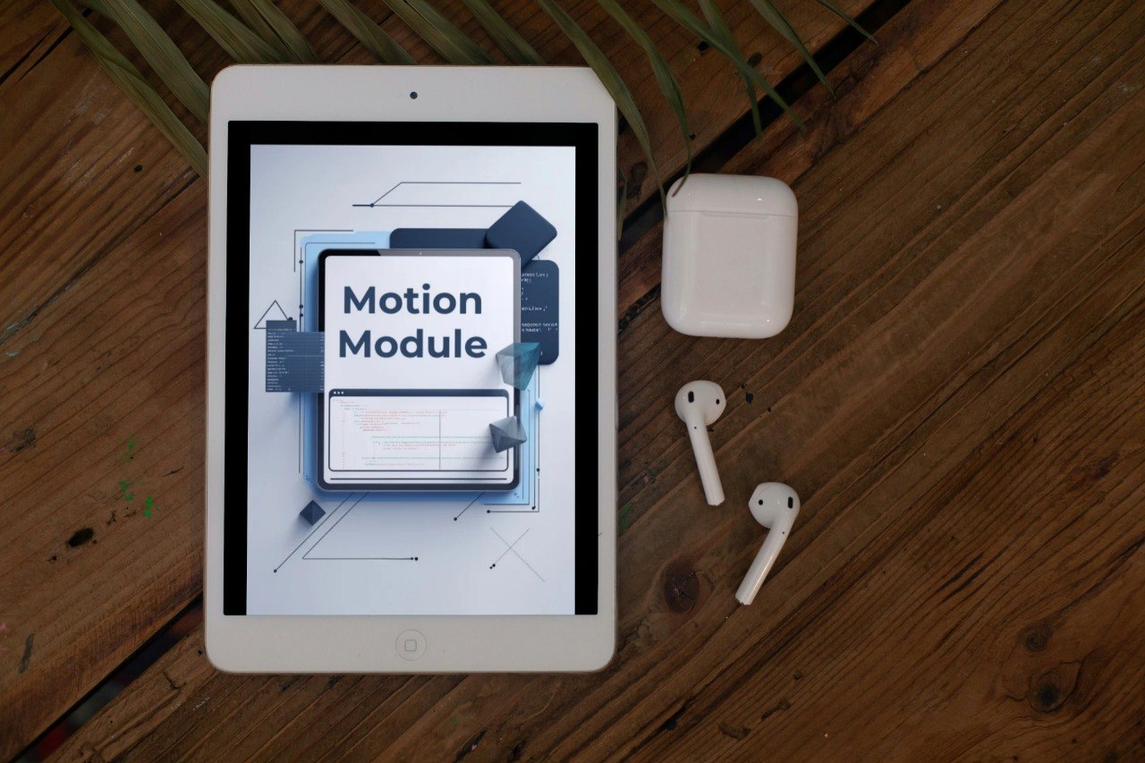 Tablet displaying 'Motion Module' on a wooden surface with AirPods.