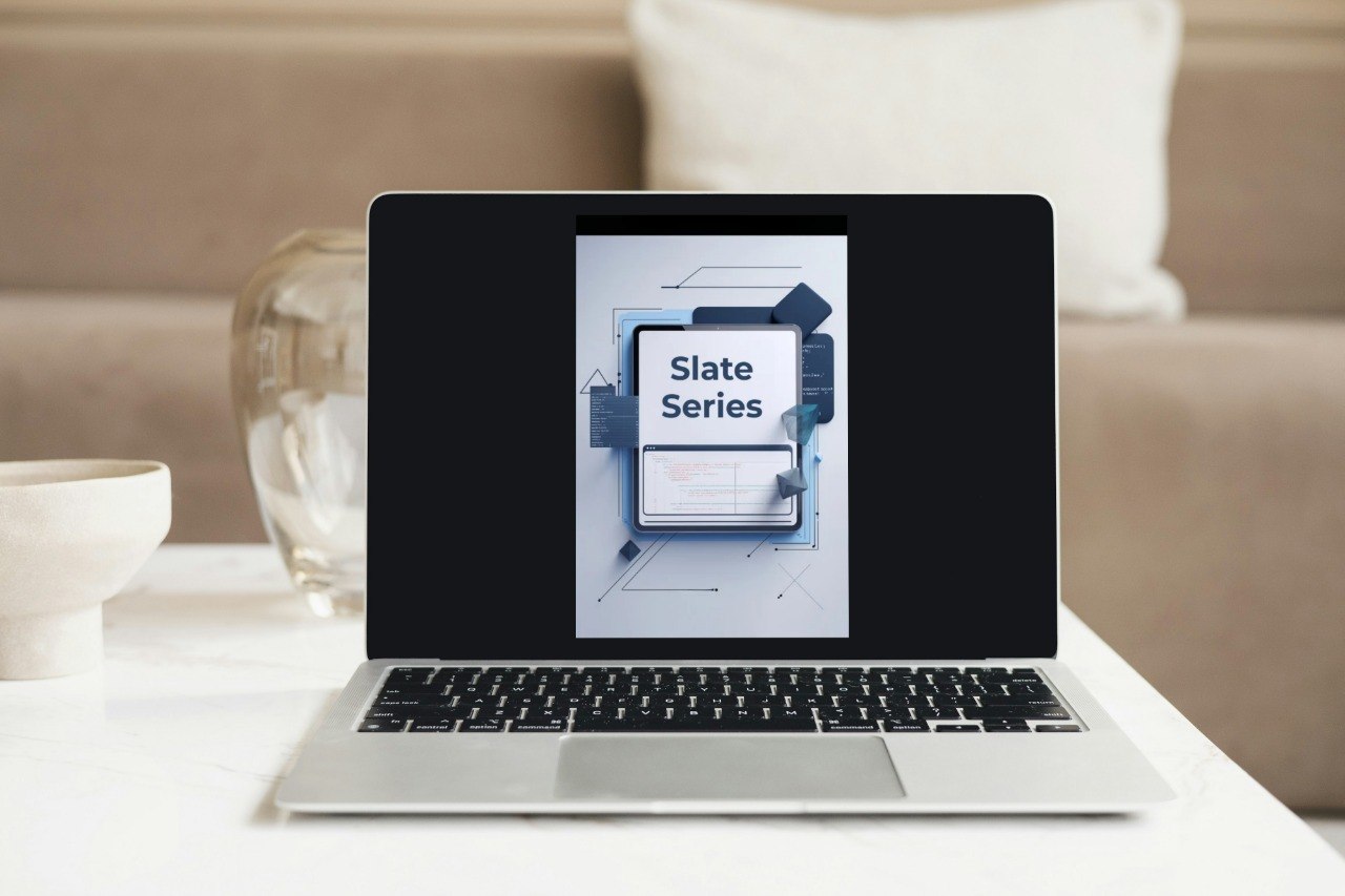 Laptop on a table with a 'Slate Series' display in a home setting